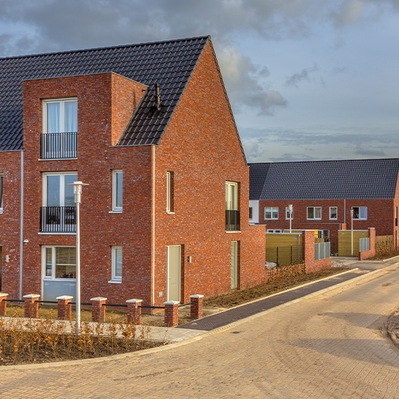 row of residential houses with a street lamp on the left side showing a speed limit sign perfect for three story homes