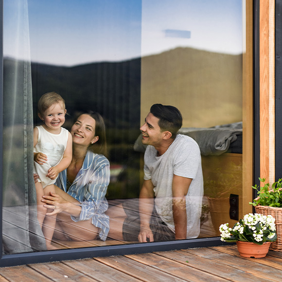 a charming ivy-covered house with brick chimneys surrounded by trees and a wooden fence depicting autumn colors and a tranquil scenery perfect for two people