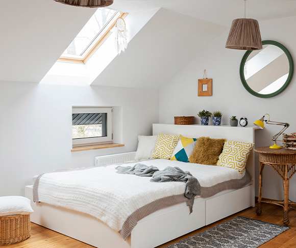 cozy bedroom with wooden beams and a bed featuring a patterned quilt stylish nightstands and ceiling fan for comfort and relaxation